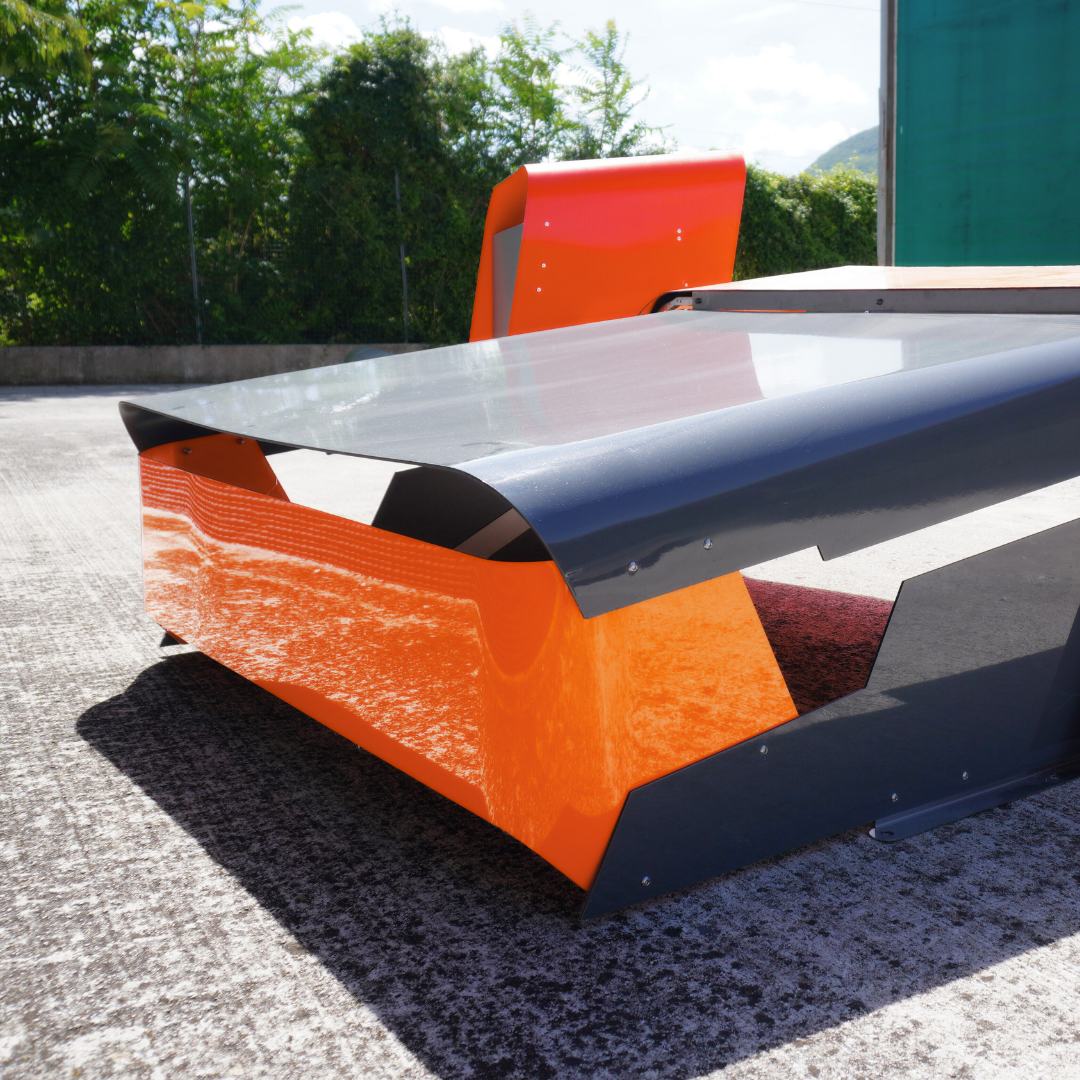 Rückdetail der CEORA Garage mit geschwungenem schwarz-orangefarbenem Dach und sichtbaren Schrauben.