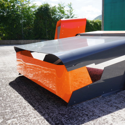 Rückdetail der CEORA Garage mit geschwungenem schwarz-orangefarbenem Dach und sichtbaren Schrauben.