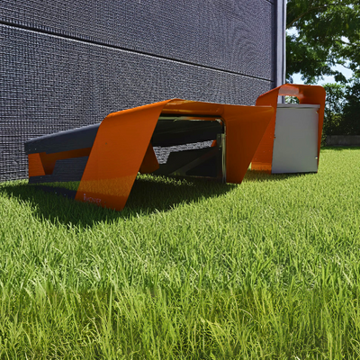 Side view of the CEORA robotic mower garage placed on grass, next to a modern building.